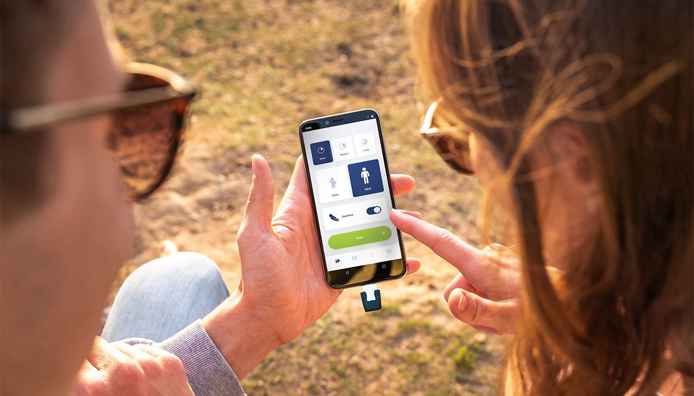 Android mit heat it App geöffnet, Stichheiler ist eingesteckt, vor verschwommenen Hintergrund