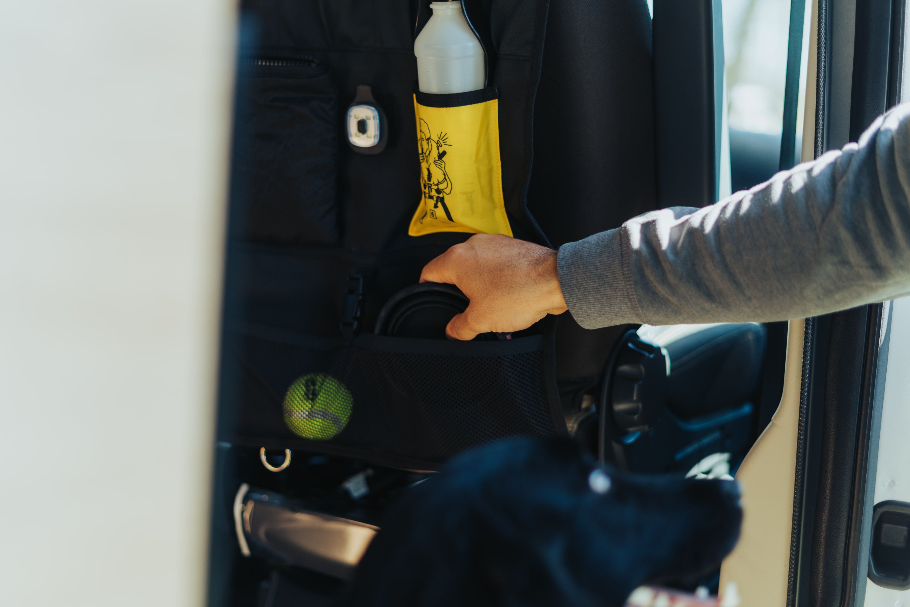 ADAC Hunde Organizer, Schwarz und gelb, Mit Hunde Grafiken an Autositz montiert, Zubehör wird verstaut