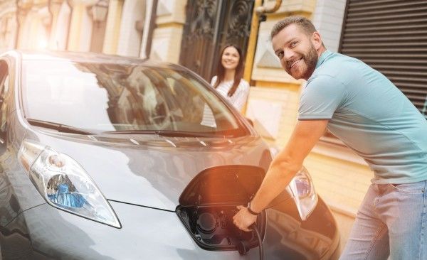 E-Auto, Mann vor Auto