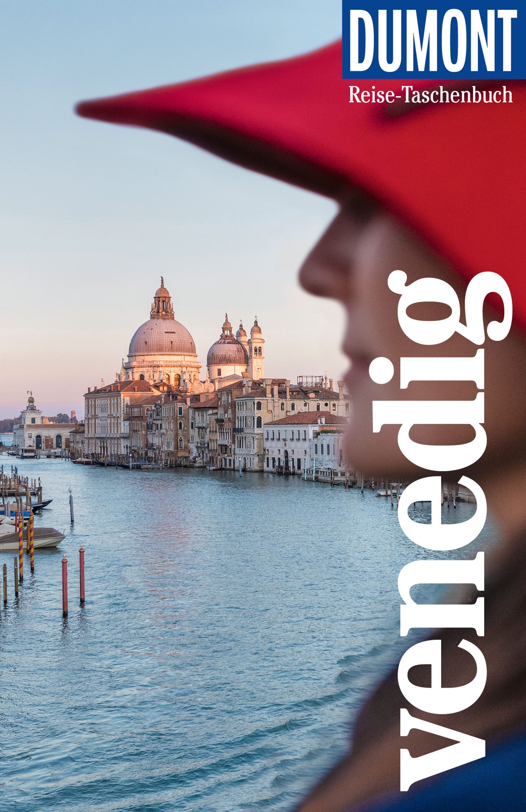 9783616007045 DuMont Reise-Taschenbuch Venedig, Cover seitliche Aufnahme einer Frau mit Petersdom im Hintergrund mit Wasser davor