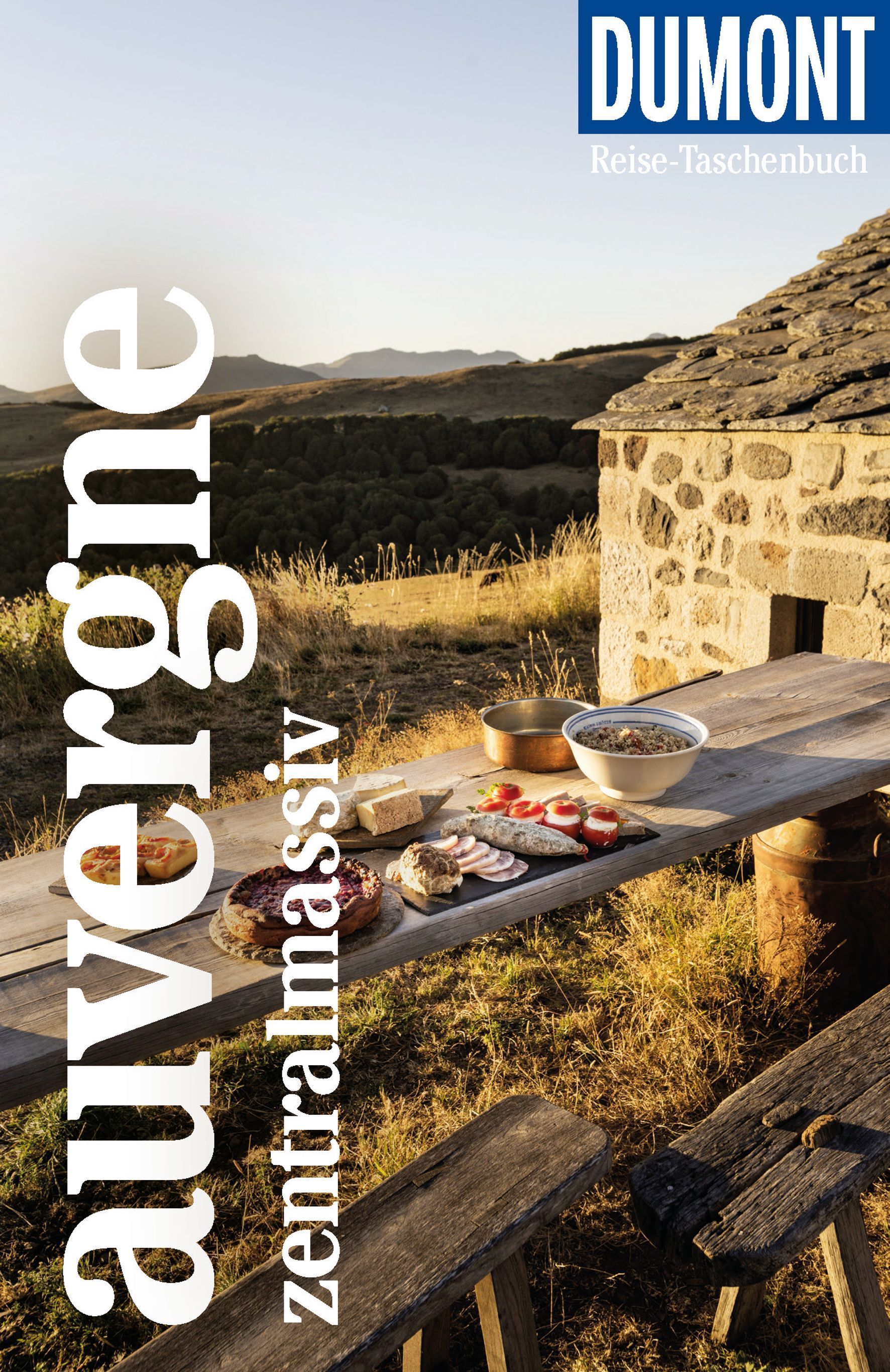 9783616020068 DuMont Reise-Taschenbuch Auvergne, Zentralmassiv, Cover alte Sitzbank mit Essen, alter Steinhütte und weite Steppe im Hintergrund