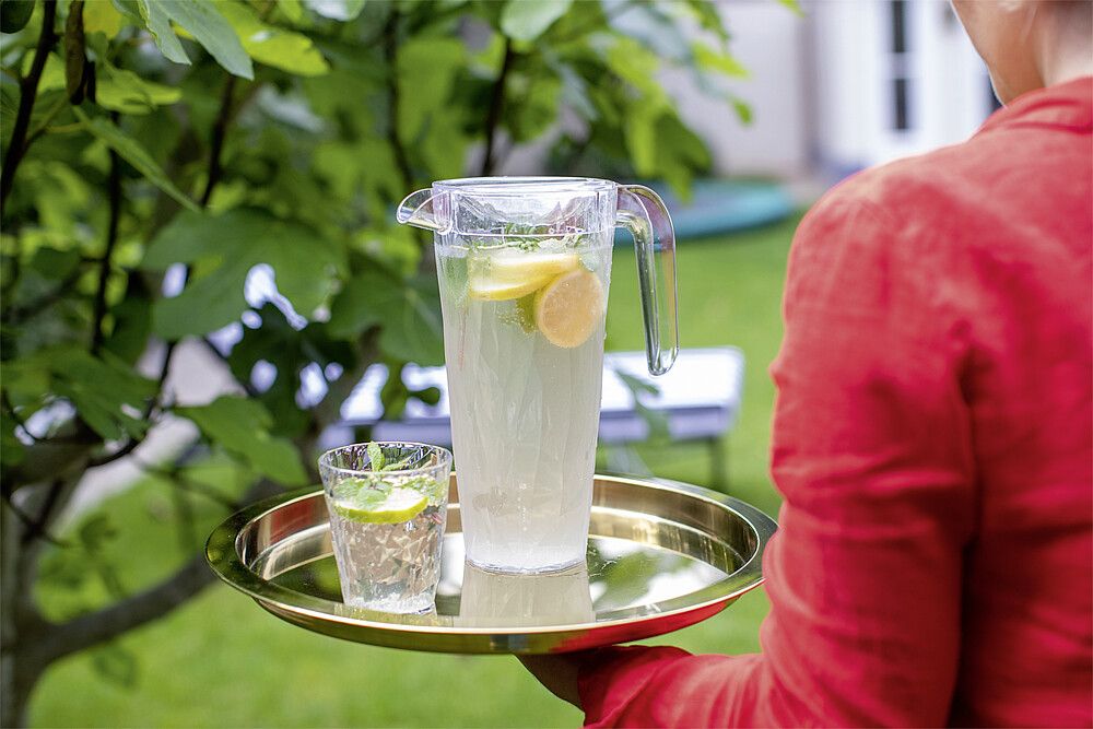 Koziol Trinkglas Superglas mit Wasser und Limettenscheibe auf Tablett mit Karaffe