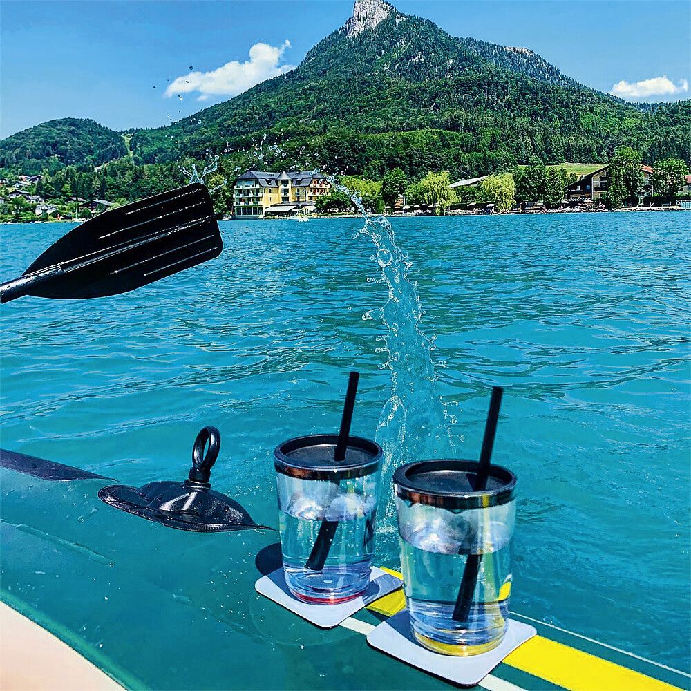 Silwy Manget-Trinkbecher an einem Schlauchboot befestigt. Auf einem See mit Landschaft im Hintergrund