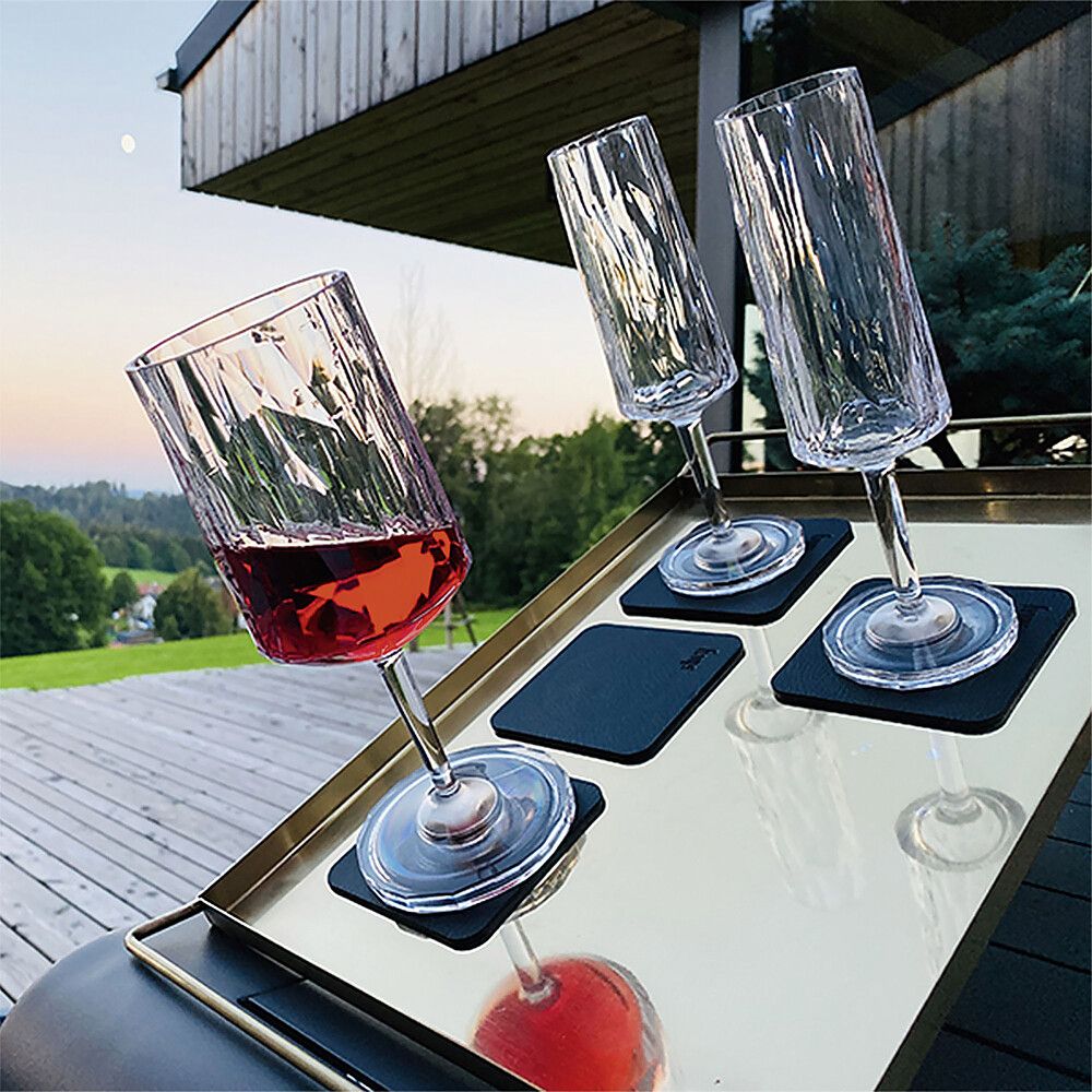 Silwy Wein und Sektgläser auf einem Tablett gestellt und trotz Neigung bester Halt. Auf einer Terrasse mit Landschaft im Hintergrund