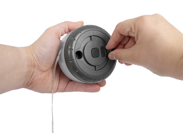 LED-Campinglampe in einer Hand, Rückseite Lampe, Ladedose