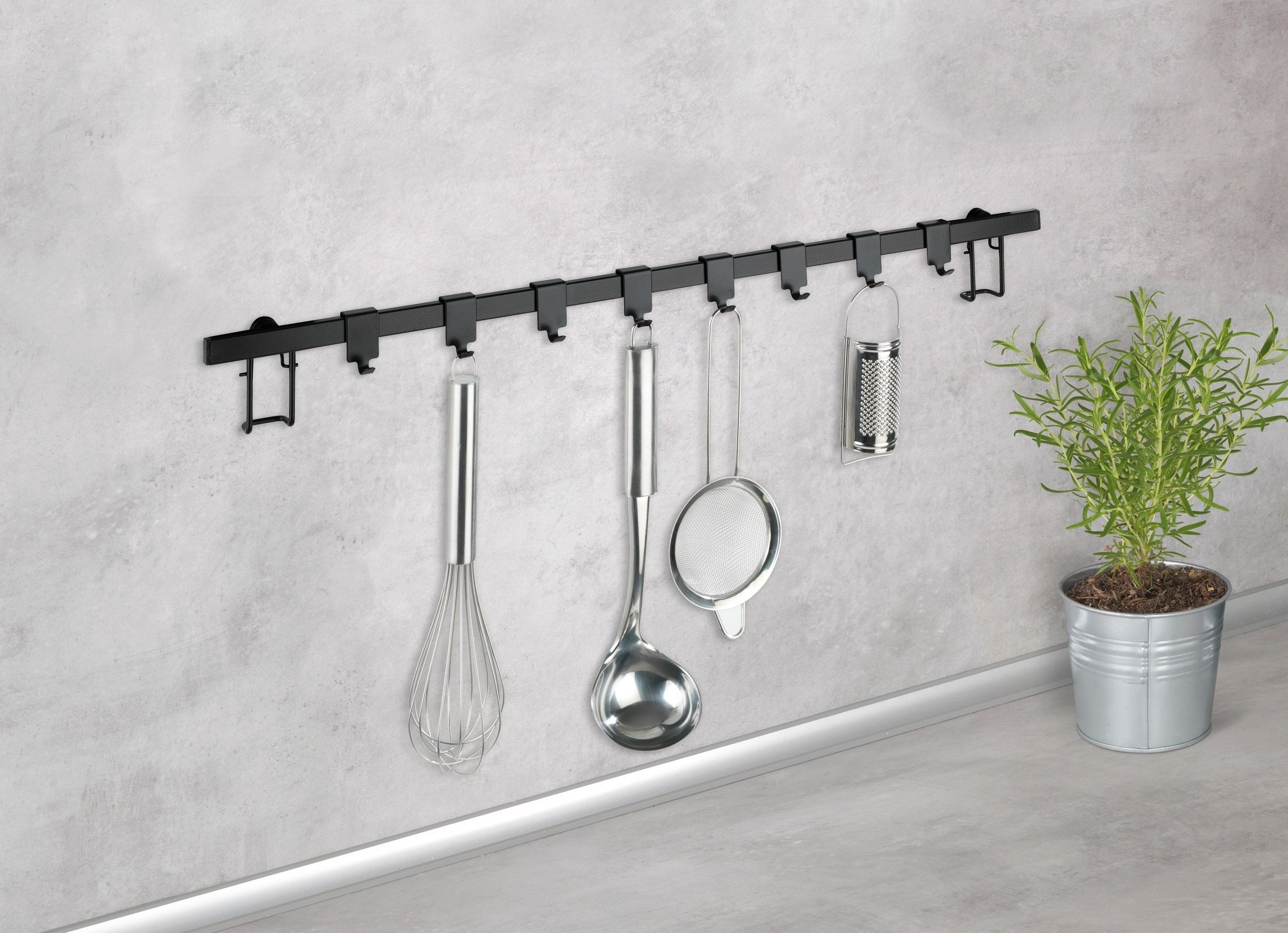 994408122 Wenko Hakenleiste Gala mit 8 Haken, auf weißem Hintergrund, mit beispielhaftem Besteck bestückt auf grauer Wand