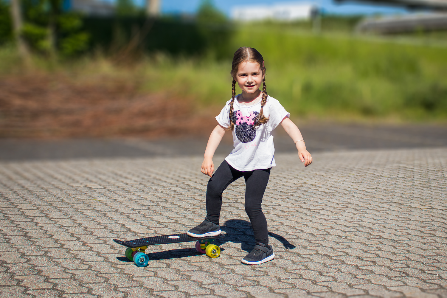 Kinderskater, Skateboard, Gummirollen, Weiße T‑Shirt, Haarzöpfe